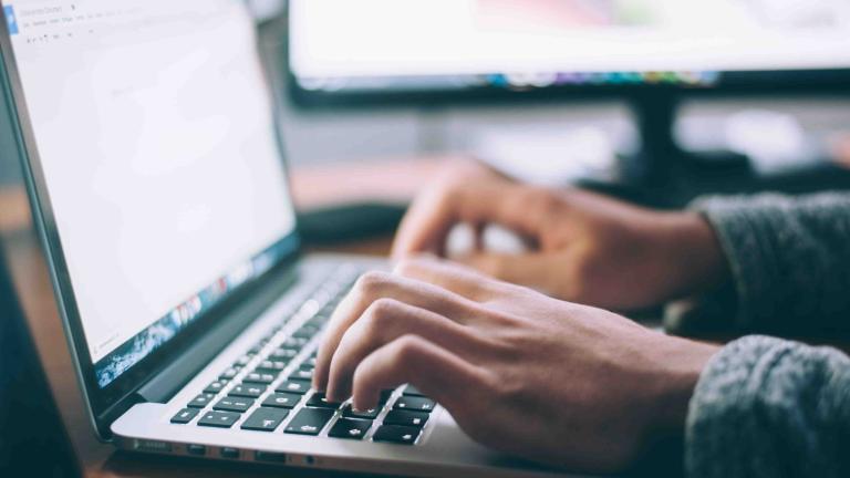Hands on a laptop keyboard