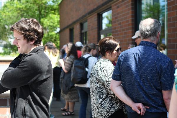 People mingle at an outdoor reception 