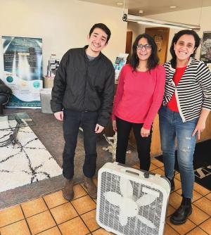 Three people pose with a box fan air cleaner