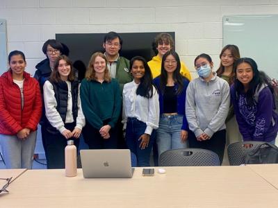 A group of young researchers pose in a classroom.